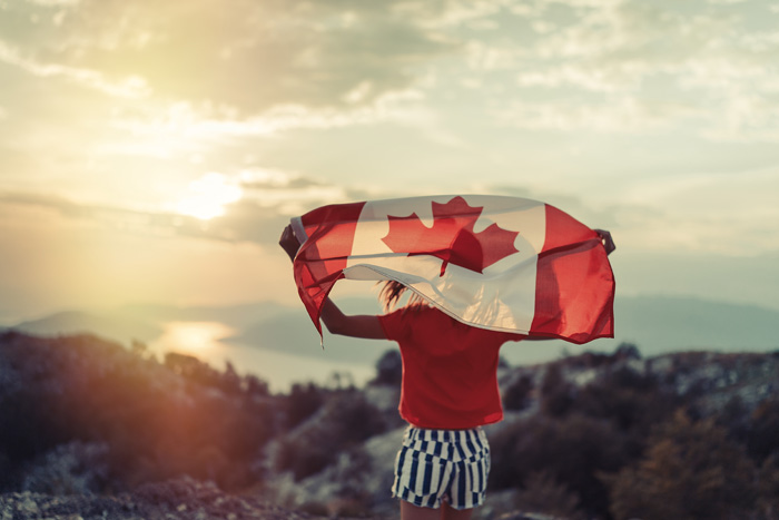 カナダ留学で得られるもの　カナダフラッグを背負う女性